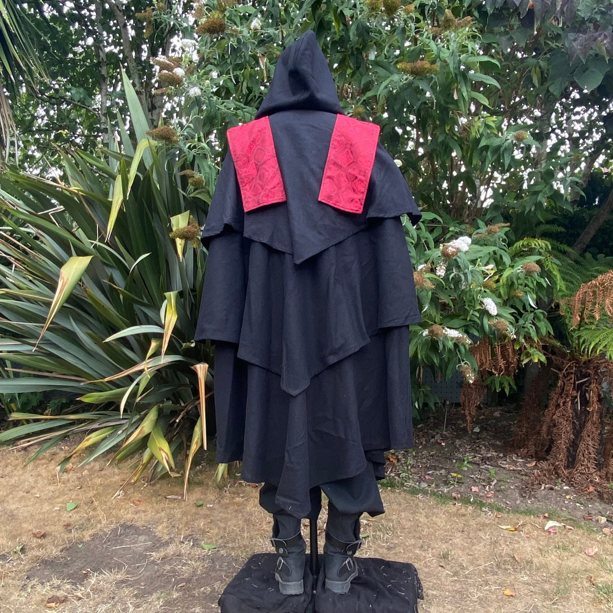 Medieval LARP costume back view featuring a 3-layered cloak, shirt, and belt.