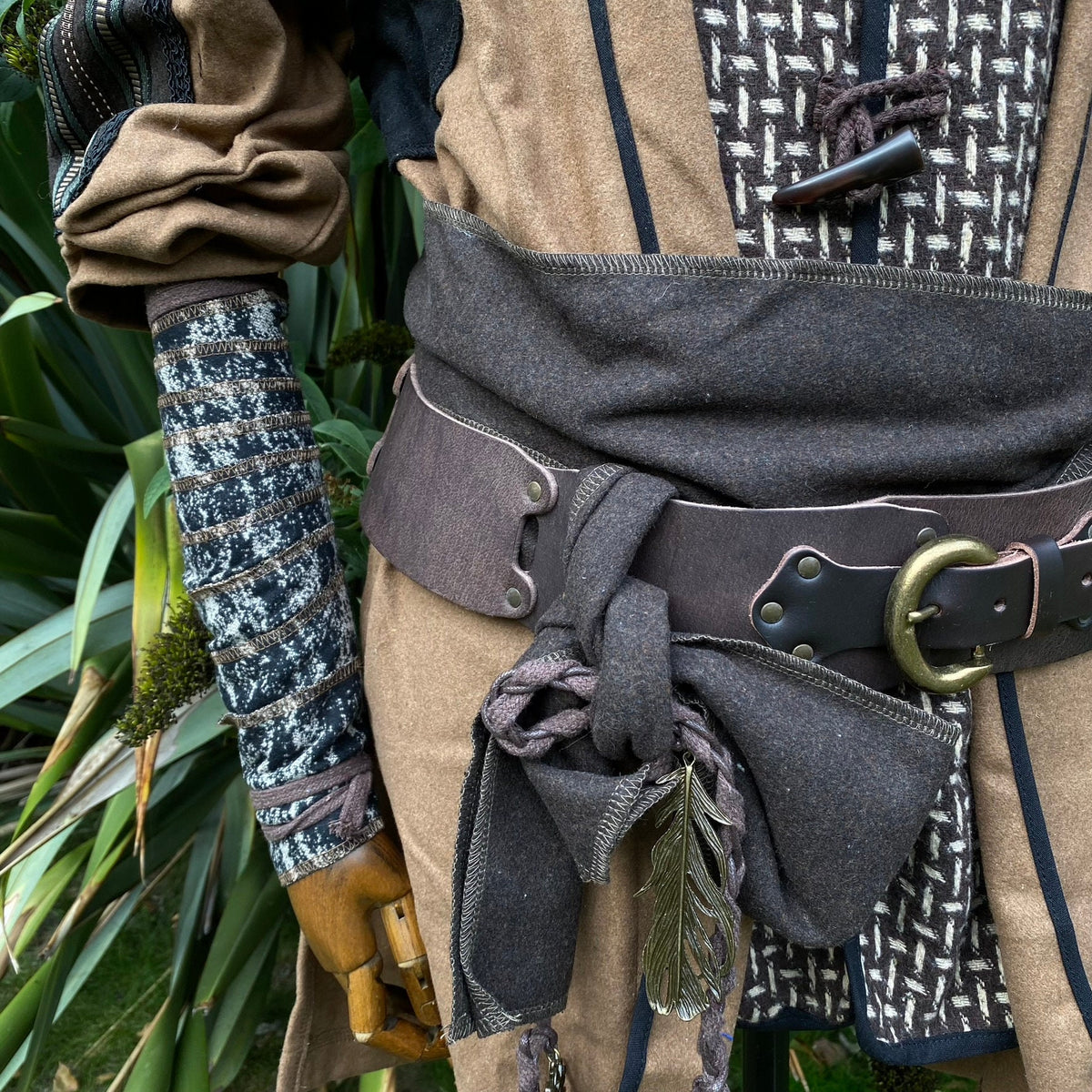 LARP medieval costume with patterned wool arm wrap and feather detail.