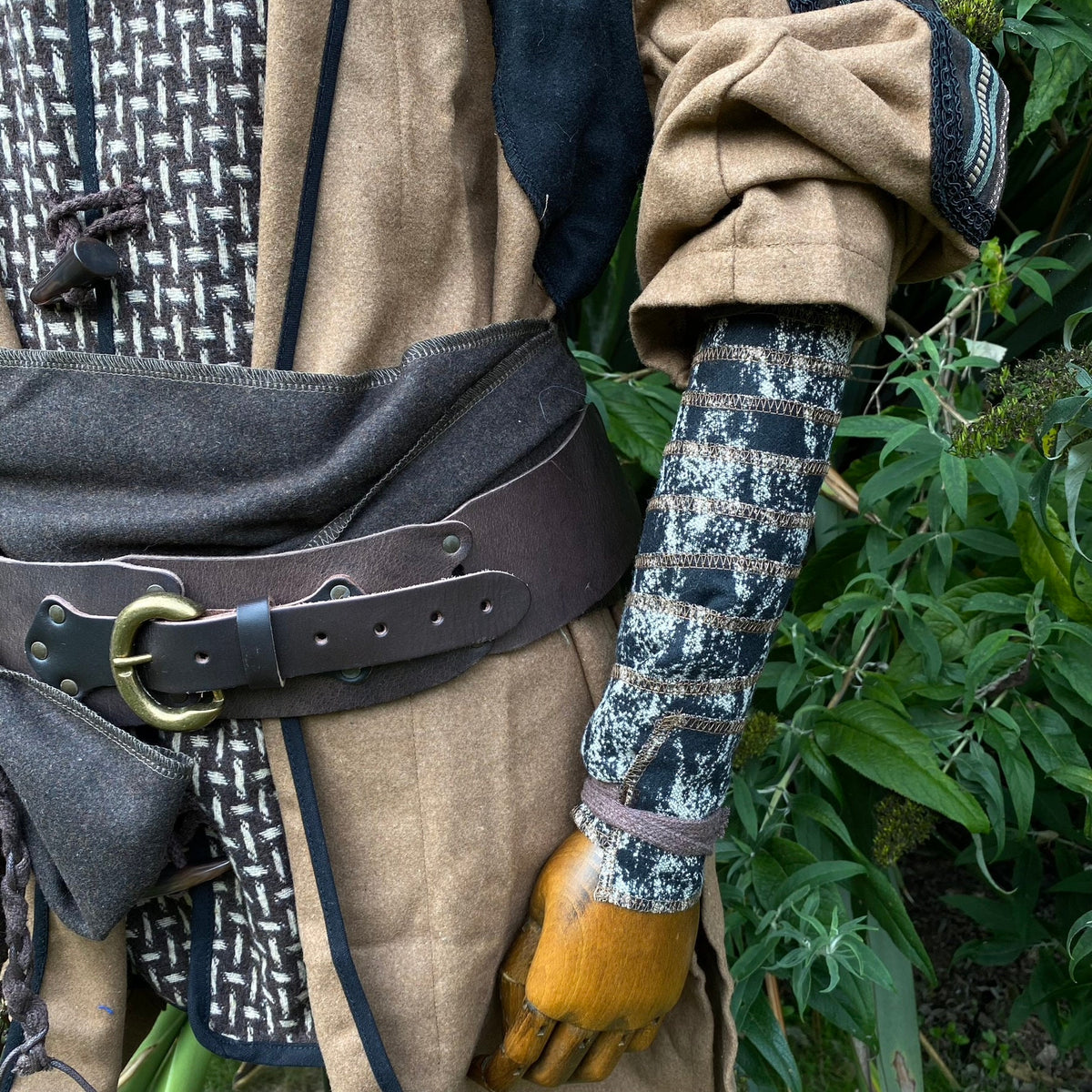 Brown and black wool arm wraps on mannequin for medieval LARP outfit.