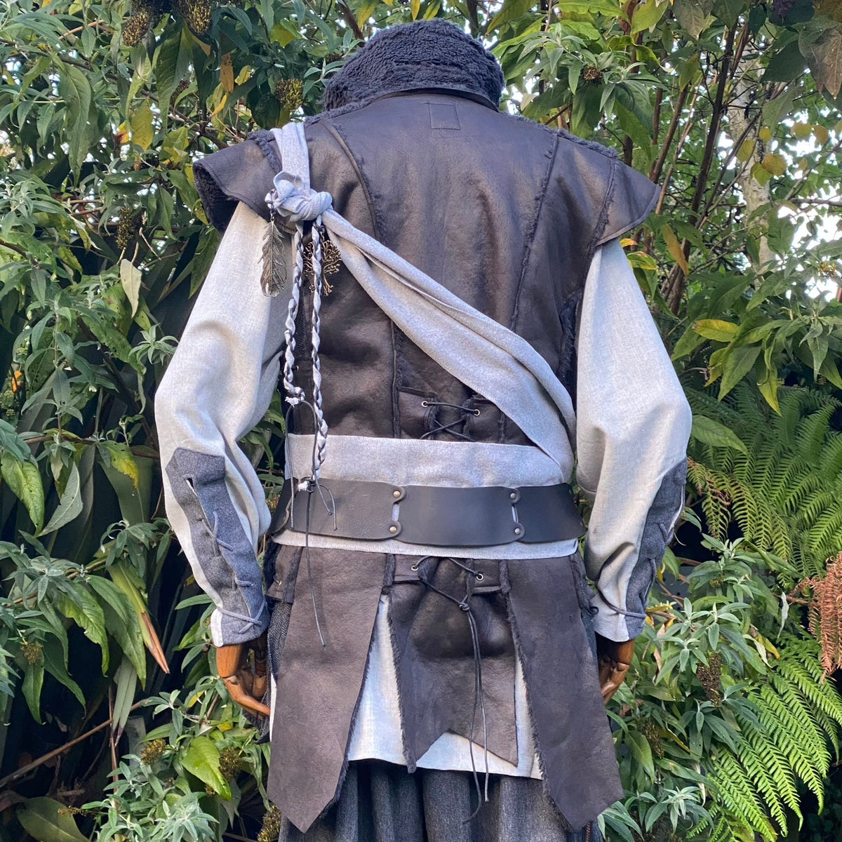 Medieval LARP outfit back view, featuring a black waistcoat, grey cotton shirt, trousers and sash.