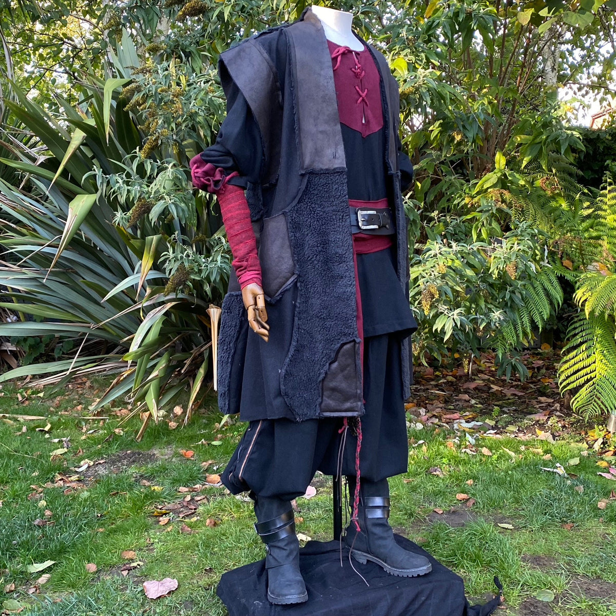 LARP waistcoat side view; black faux leather, red tunic accents.
