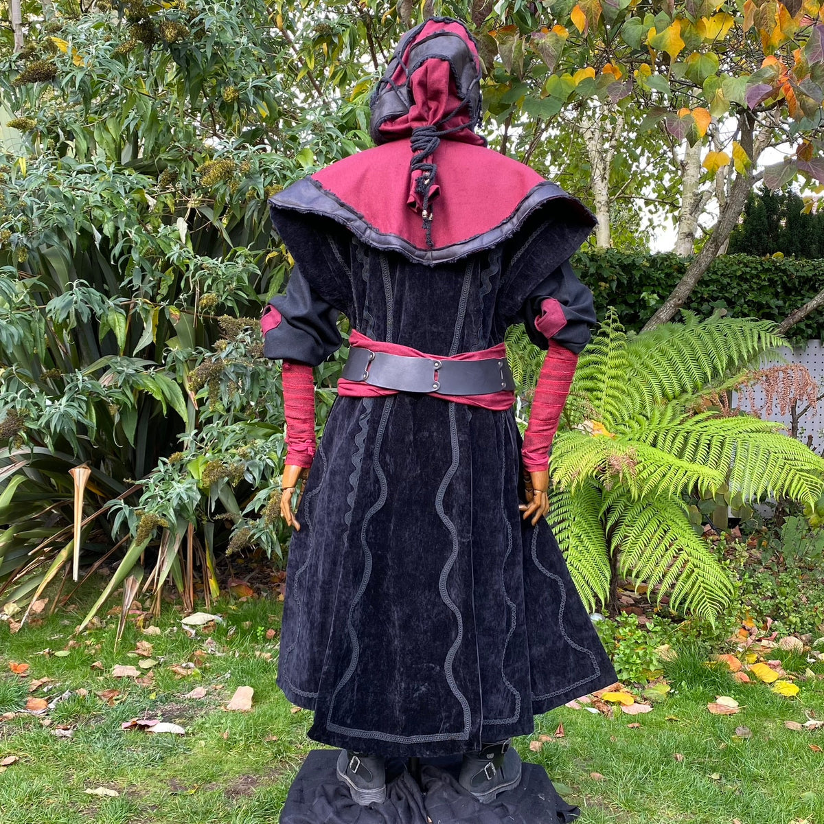 Back view of medieval LARP costume with red hood and black waistcoat.