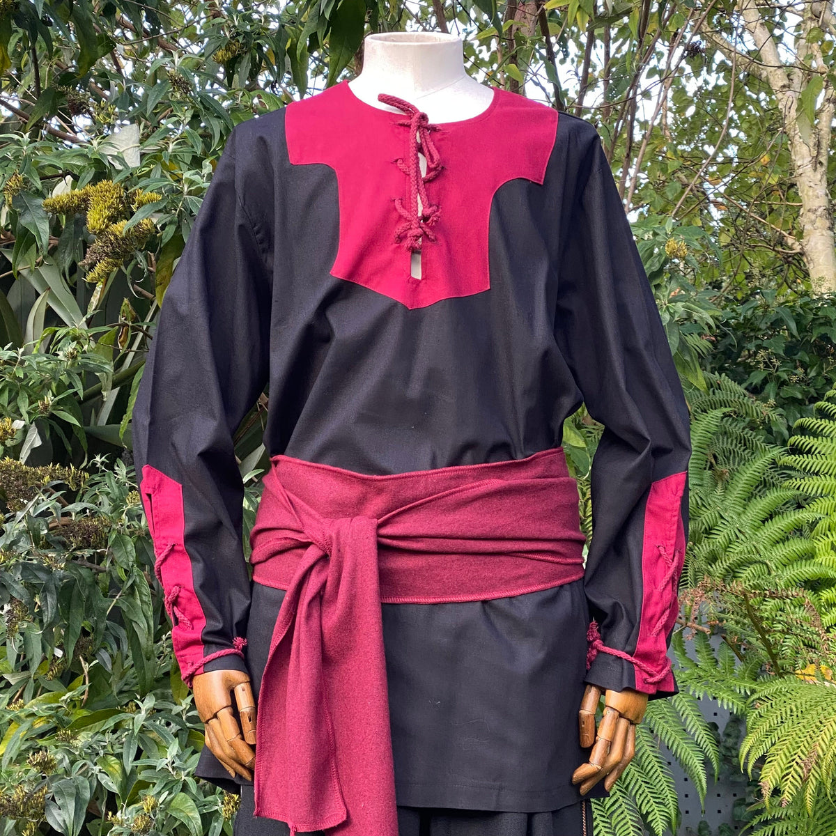 LARP outfit with red laced neckline and sash, front view.