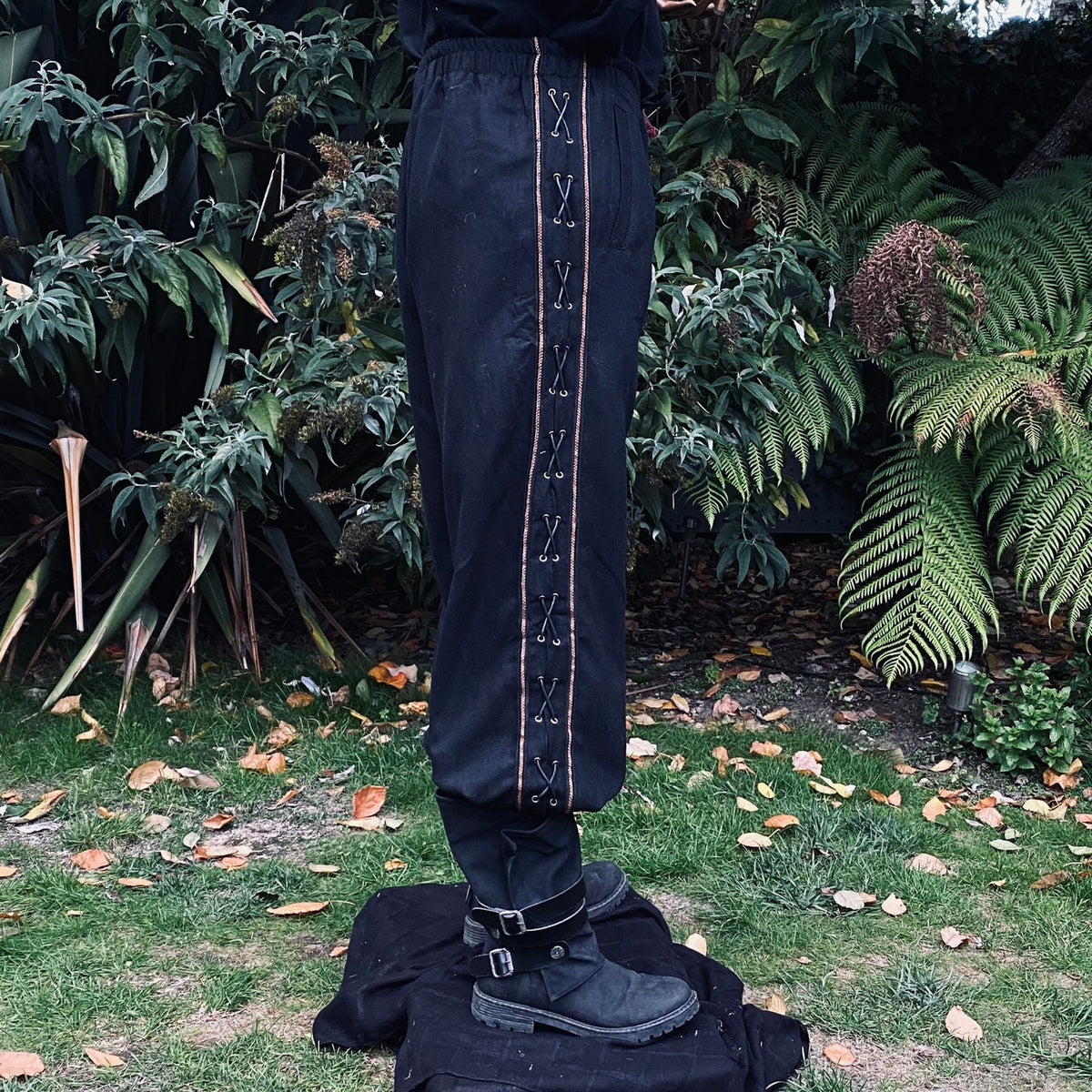 Black Viking trousers with side lacing, worn.