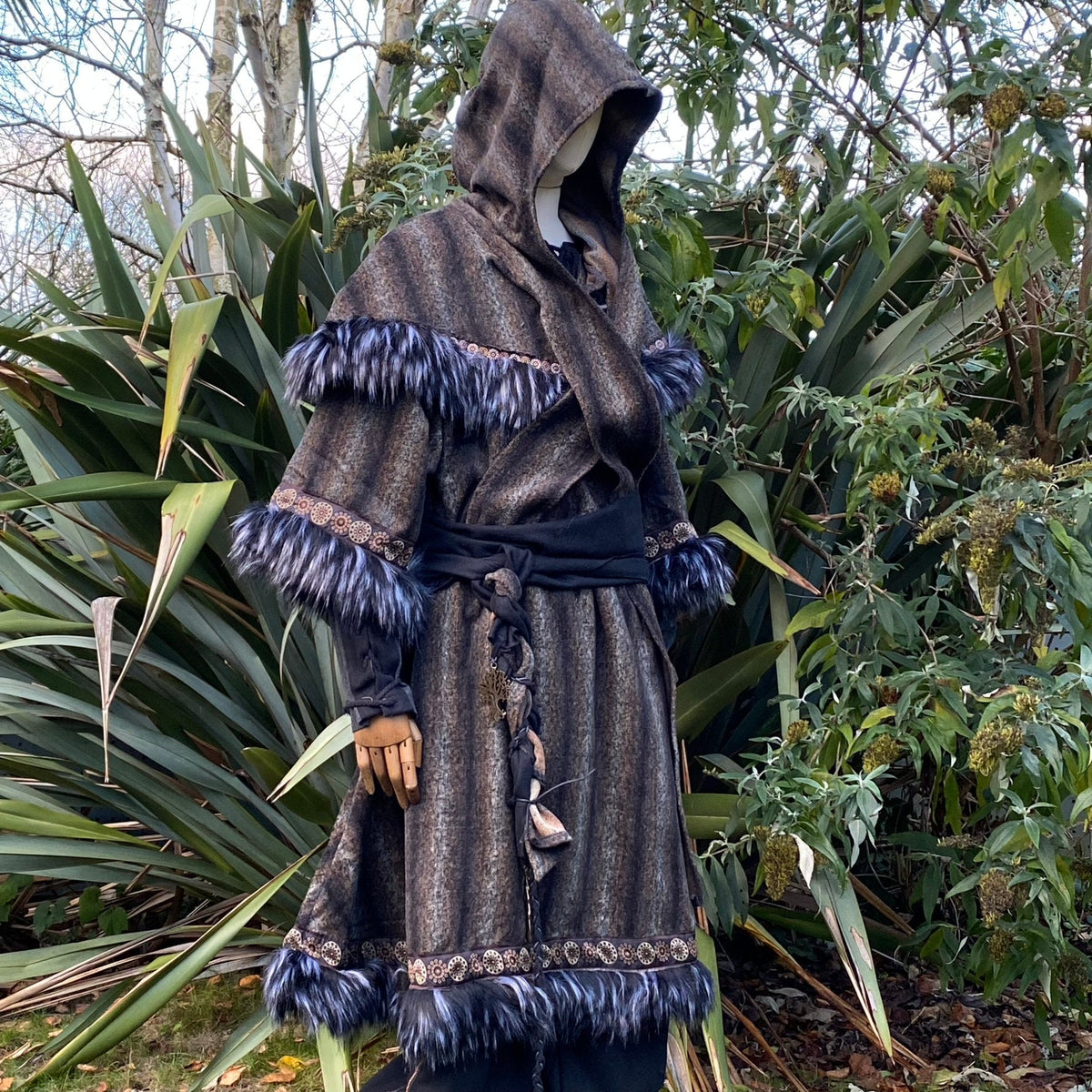 Medieval LARP outfit side view, featuring a brown and black fur trim tunic, matching hood, and sash.