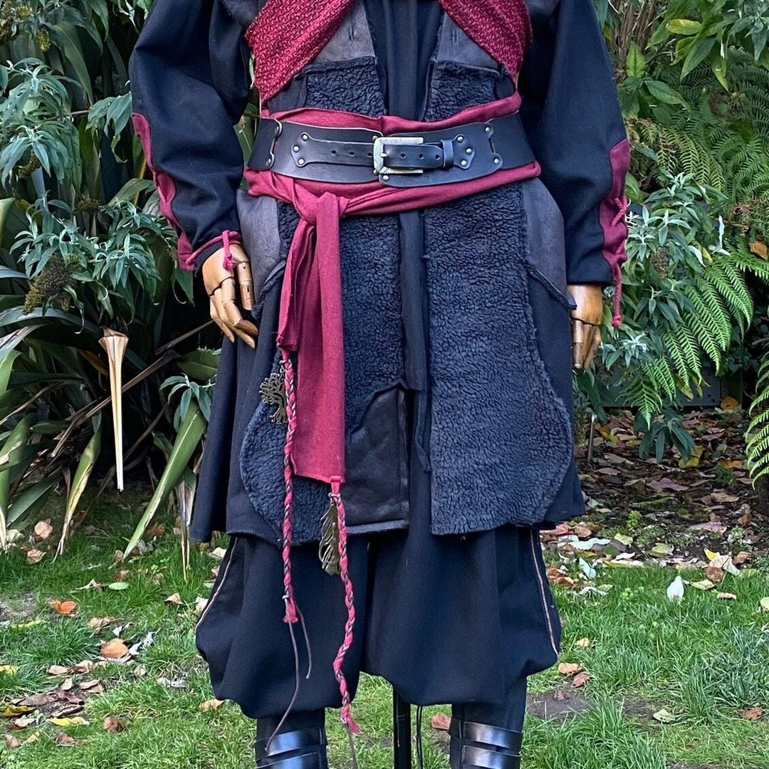 A LARP Belt and Costume Sash Set. The LARP Belt is made from Buffalo Leather in Black. The Viking Sash is a Red Wool sash that works well by itself, or underneath the LARP Belt. The Medieval Sash has a decorated metal accessories that adds to your LARP Character, Cosplay, or Ren Faire event.