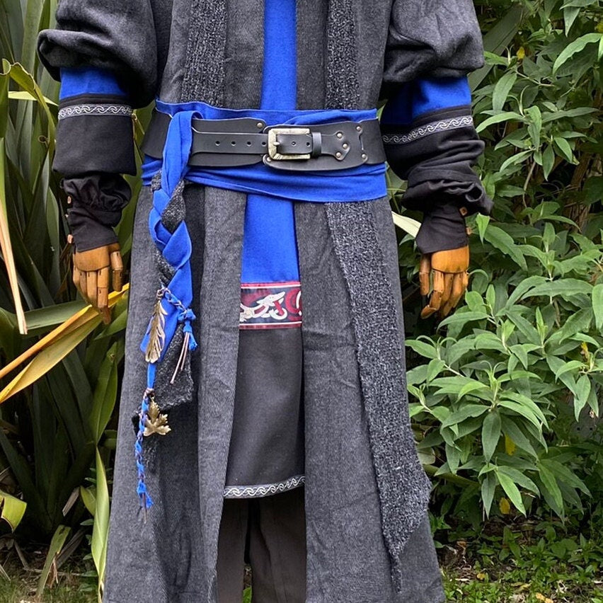 A LARP Belt and Costume Sash Set. The LARP Belt is made from Buffalo Leather in Black. The Viking Sash is a Blue Wool sash that works well by itself, or underneath the LARP Belt. The Medieval Sash has a decorated metal accessories that adds to your LARP Character, Cosplay, or Ren Faire event.