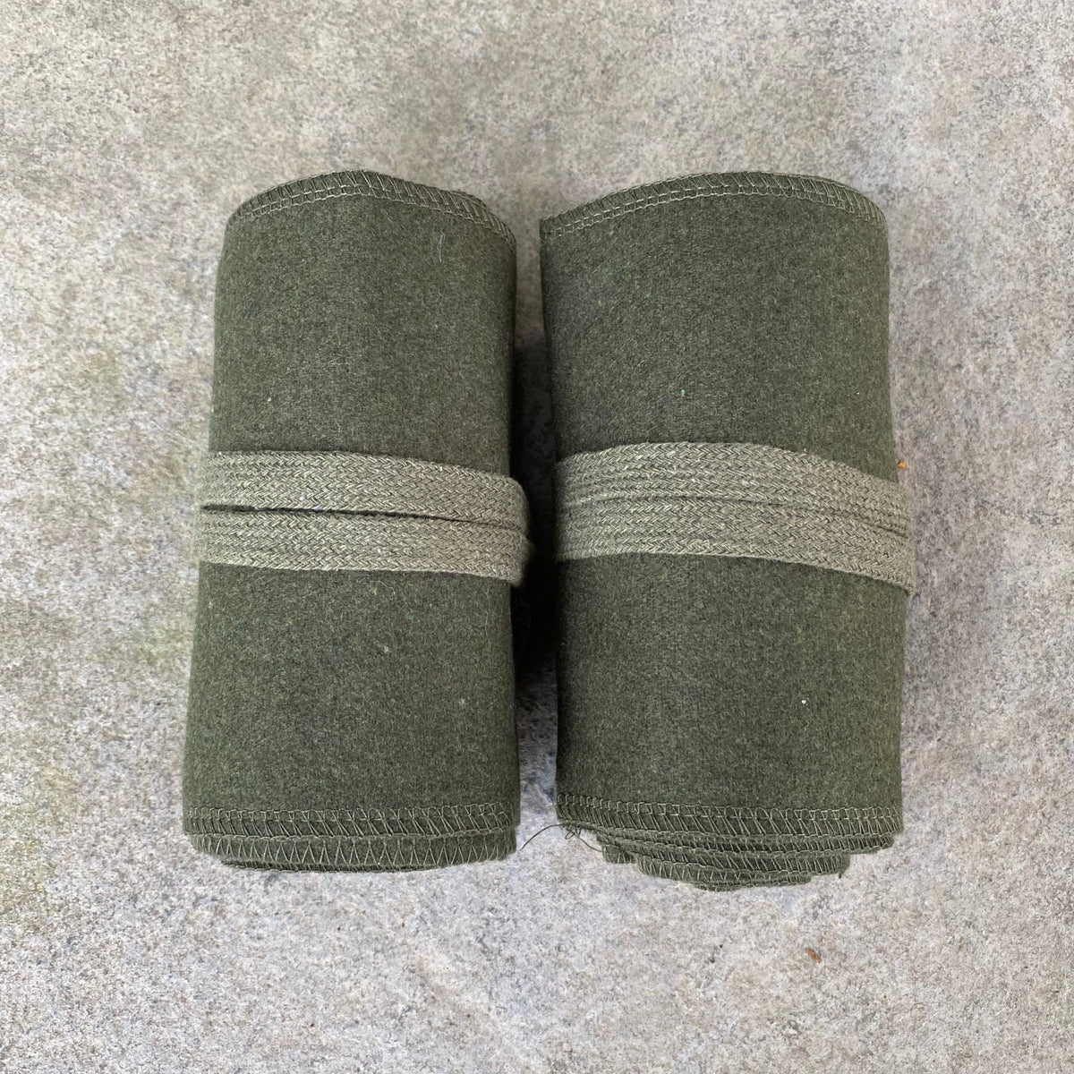 Dark green woolen leg wraps rolled up for medieval LARP attire.