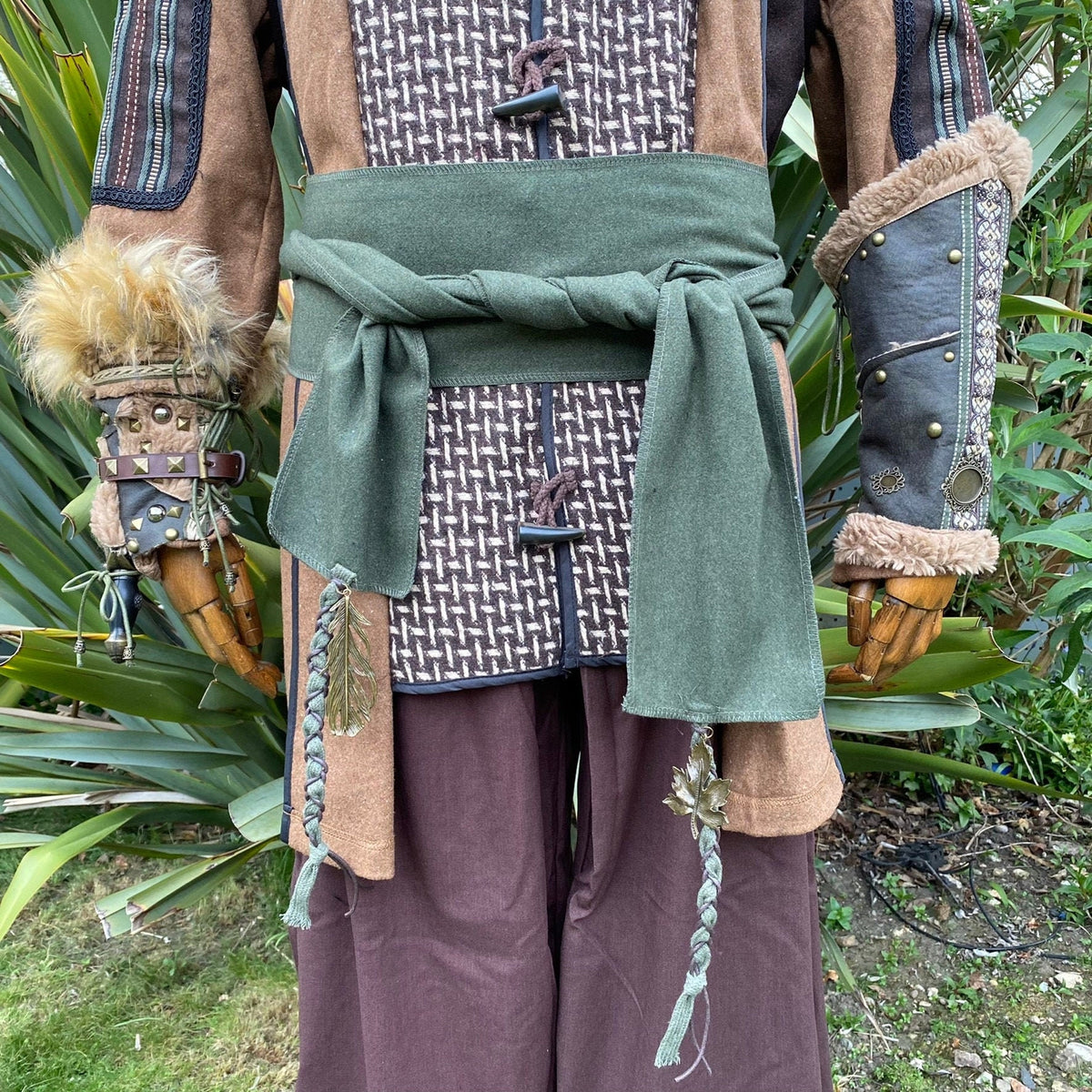 Medieval LARP wool sash on patterned tunic with braided tassels.