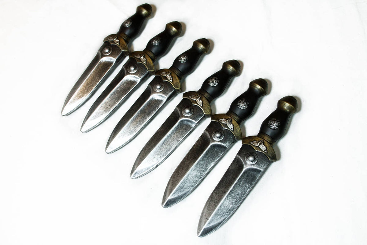 Six LARP daggers in a row, side view, pewter finish and ornate details.