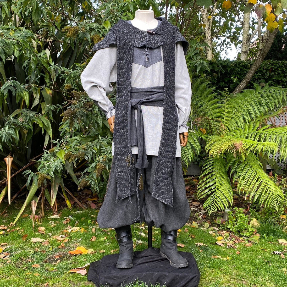 Grey wool scarf hood drapes over mannequin in medieval LARP.