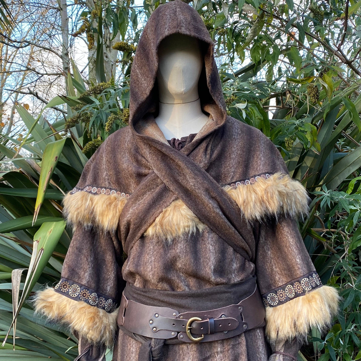 Medieval brown hood with fur trim, front view in garden setting, LARP costume.