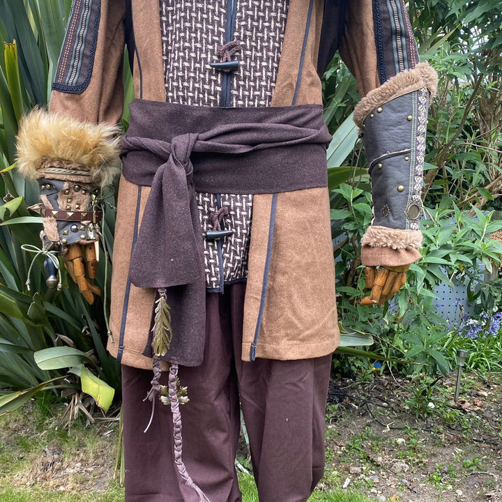 A Brown Wool LARP Sash. The Viking Sash is a Woollen sash that works well by itself, or underneath a LARP Belt. The LARP Sash is 300cm long, and can comfortably wrap around you. The Medieval Sash has a decorated metal accessories that adds to your LARP Character, Cosplay, or Ren Faire event.