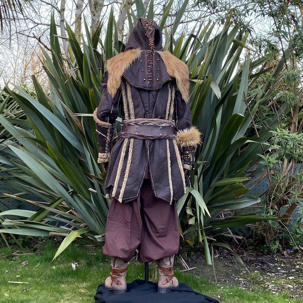 Medieval LARP costume back view featuring a brown faux leather jacket, hood and vambraces, shirt, trousers and sash. For Renaissance Faire and historical roleplay events.