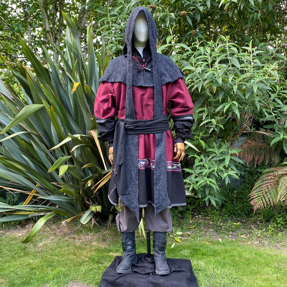 Medieval LARP outfit on mannequin, red-black tunic with grey hood.