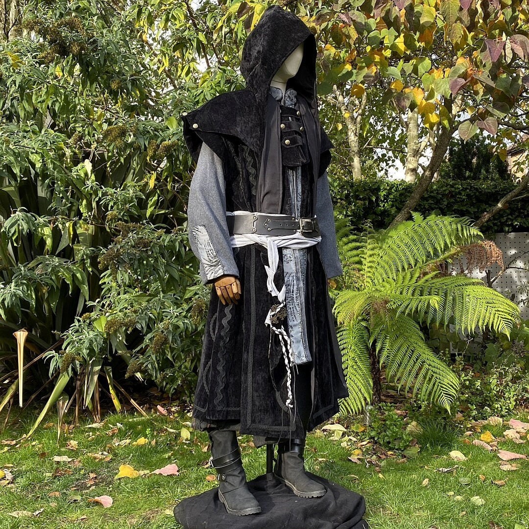 Medieval LARP outfit with hooded coat, silver accents under autumn foliage.