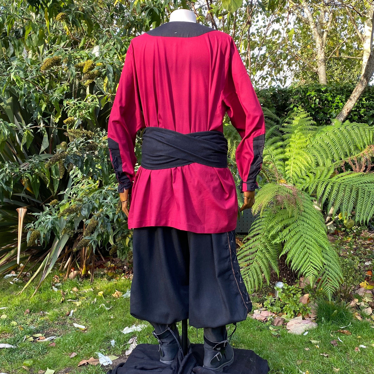 Back view of LARP attire: red tunic, black pants, and sash.
