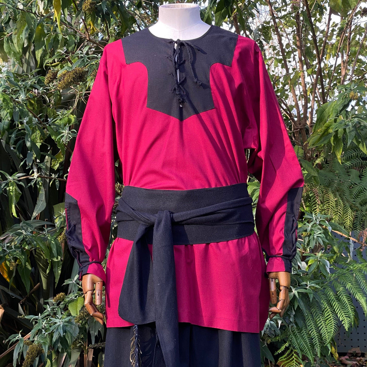 Medieval LARP attire: red-black shirt with sash detail.