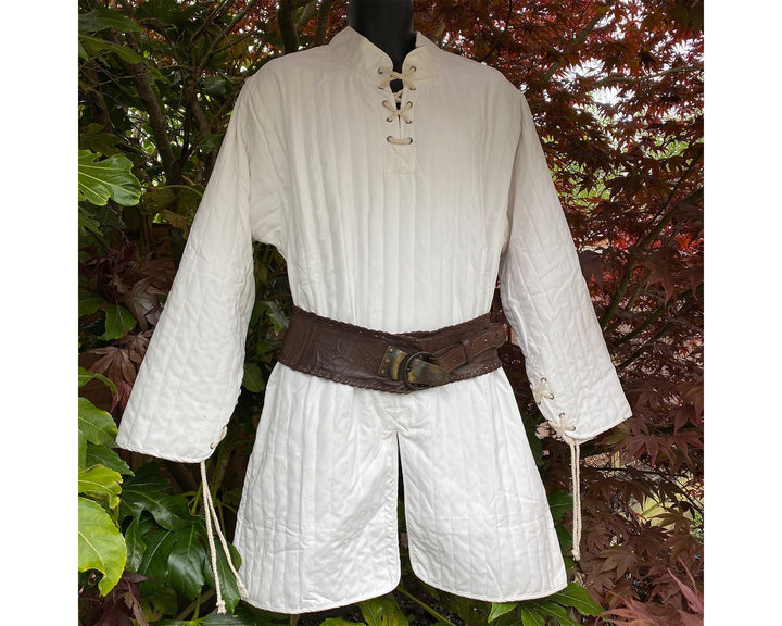 This Thin LARP Gambeson comes in White Cotton. This Padded Tunic can sit on top of the rest of your kit. This Lightweight Gambeson is water resistant and keeps you warm. This Viking Tunic is perfect for your LARP Costume and LARP Character, Cosplay Events, and Ren Faires.