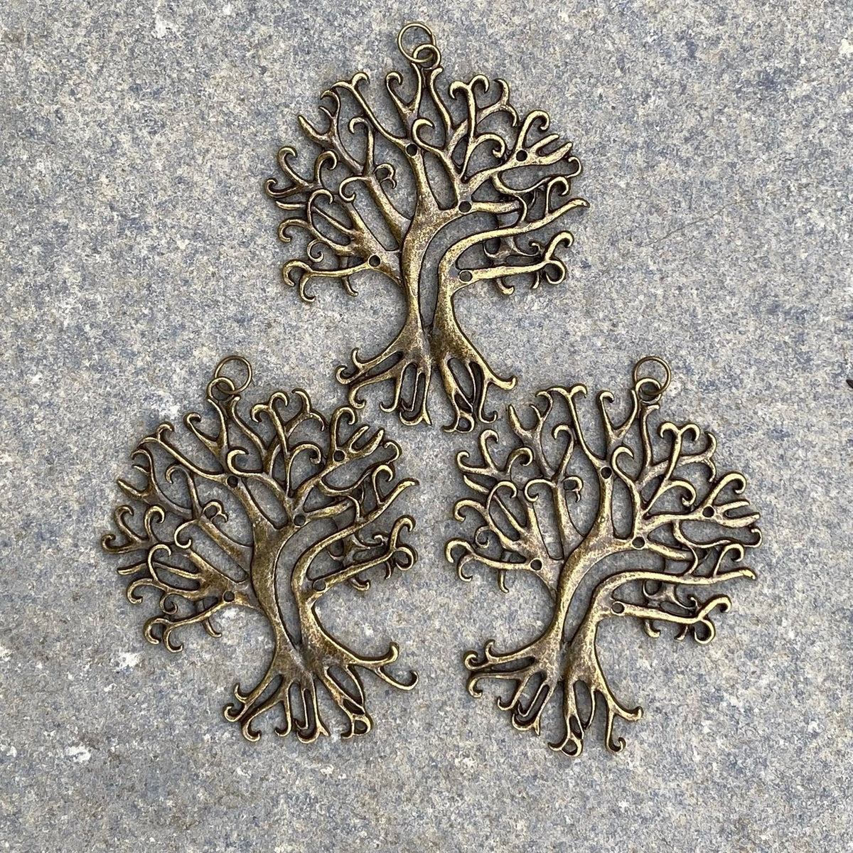 Three brass tree necklaces on stone, intricate branches, for LARP or medieval wear.