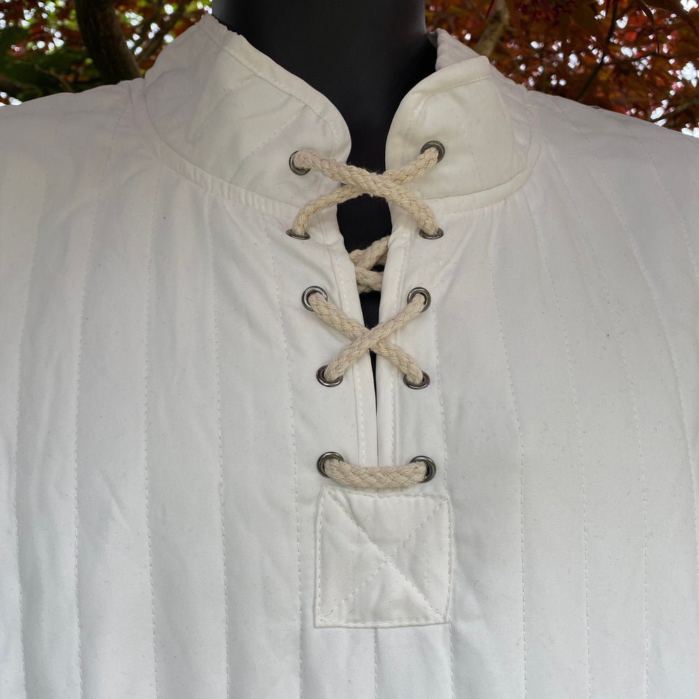 This Thin LARP Gambeson comes in White Cotton. This Padded Tunic can sit on top of the rest of your kit. This Lightweight Gambeson is water resistant and keeps you warm. This Viking Tunic is perfect for your LARP Costume and LARP Character, Cosplay Events, and Ren Faires.
