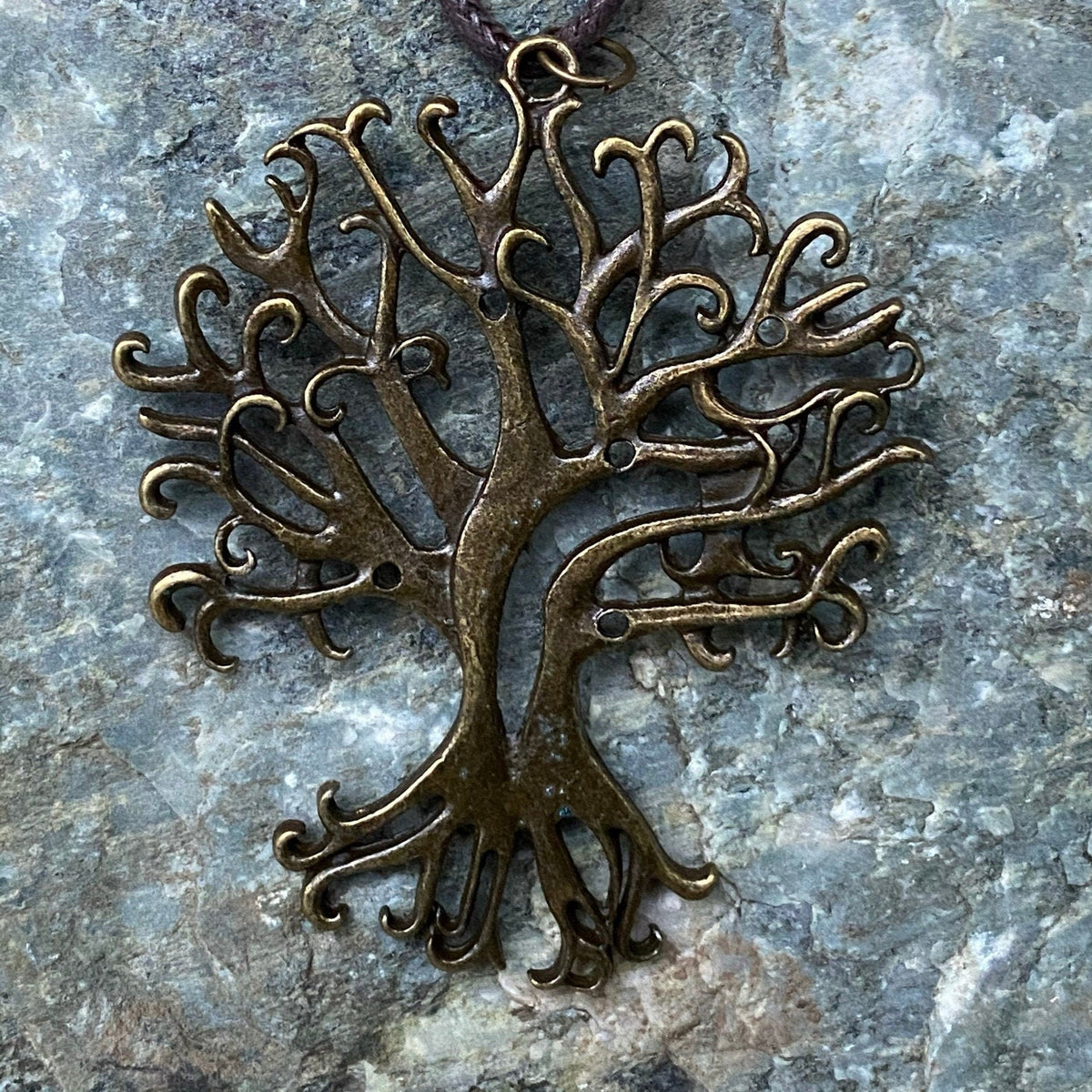 Brass tree charm necklace close-up on stone for LARP.