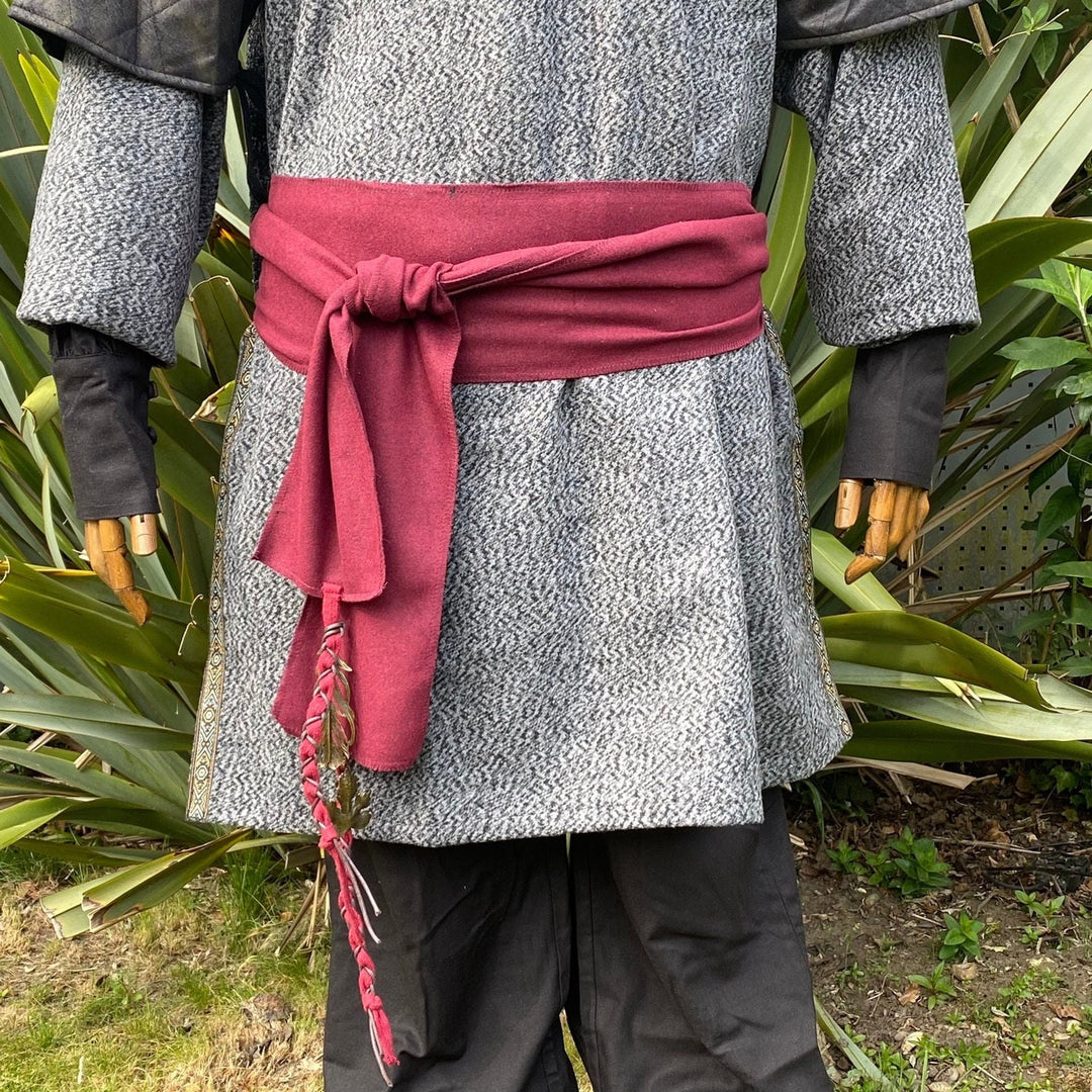 A Red Wool LARP Sash. The Viking Sash is a Woollen sash that works well by itself, or underneath a LARP Belt. The LARP Sash is 300cm long, and can comfortably wrap around you. The Medieval Sash has a decorated metal accessories that adds to your LARP Character, Cosplay, or Ren Faire event.
