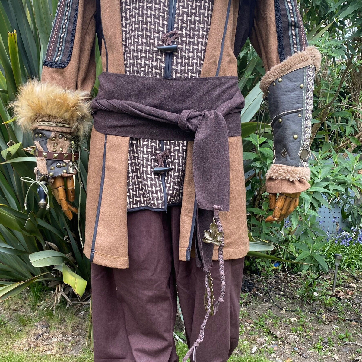Brown wool LARP sash draped on medieval costume with decorative leaves.