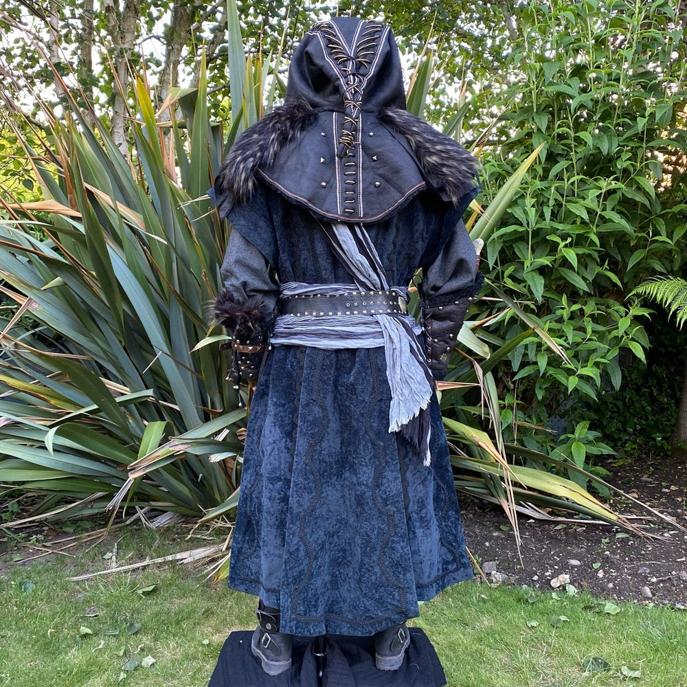 Medieval LARP costume back view featuring waistcoat, shirt, hood, vambraces, trousers, and accessories. For Renaissance Faire and historical roleplay events.