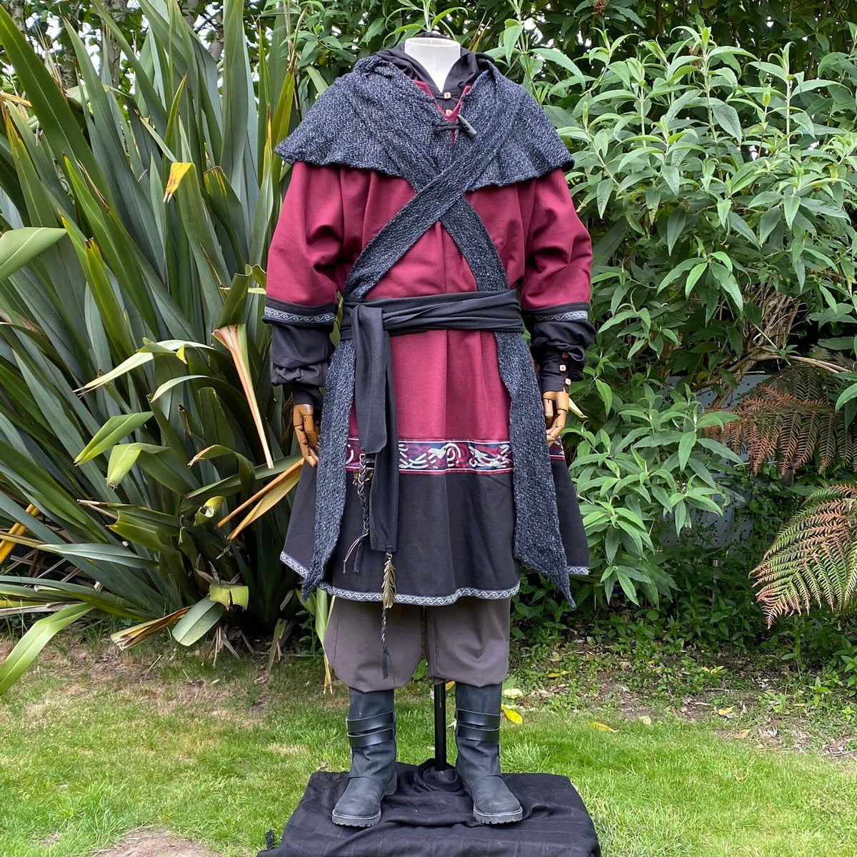 Medieval LARP outfit with red tunic, grey hood, and black sash.