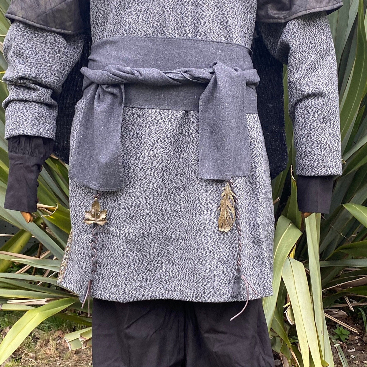 Dark grey LARP sash over medieval tunic with leaf and feather embellishments.
