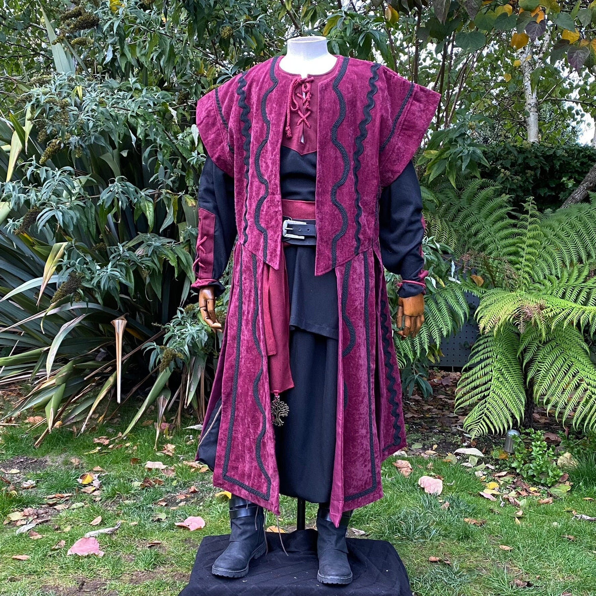 Crimson medieval waistcoat set, outdoor display, black boots visible.