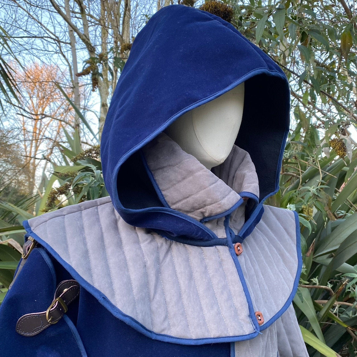 Azure medieval LARP jacket with hood and sash, close-up, quilted fabric.
