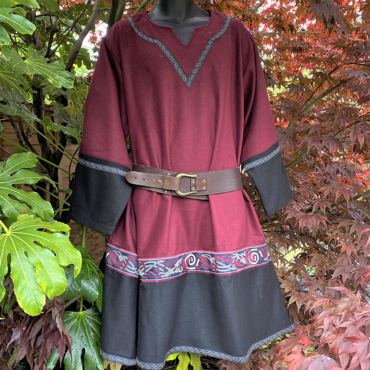Mannequin displaying red-black Viking tunic with belt, medieval LARP style.