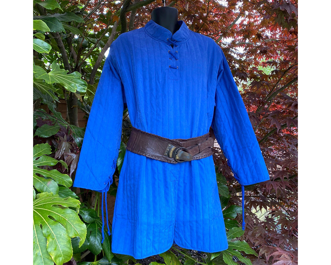 This Thin LARP Gambeson comes in Blue Cotton. This Padded Tunic can sit on top of the rest of your kit. This Lightweight Gambeson is water resistant and keeps you warm. This Viking Tunic is perfect for your LARP Costume and LARP Character, Cosplay Events, and Ren Faires.