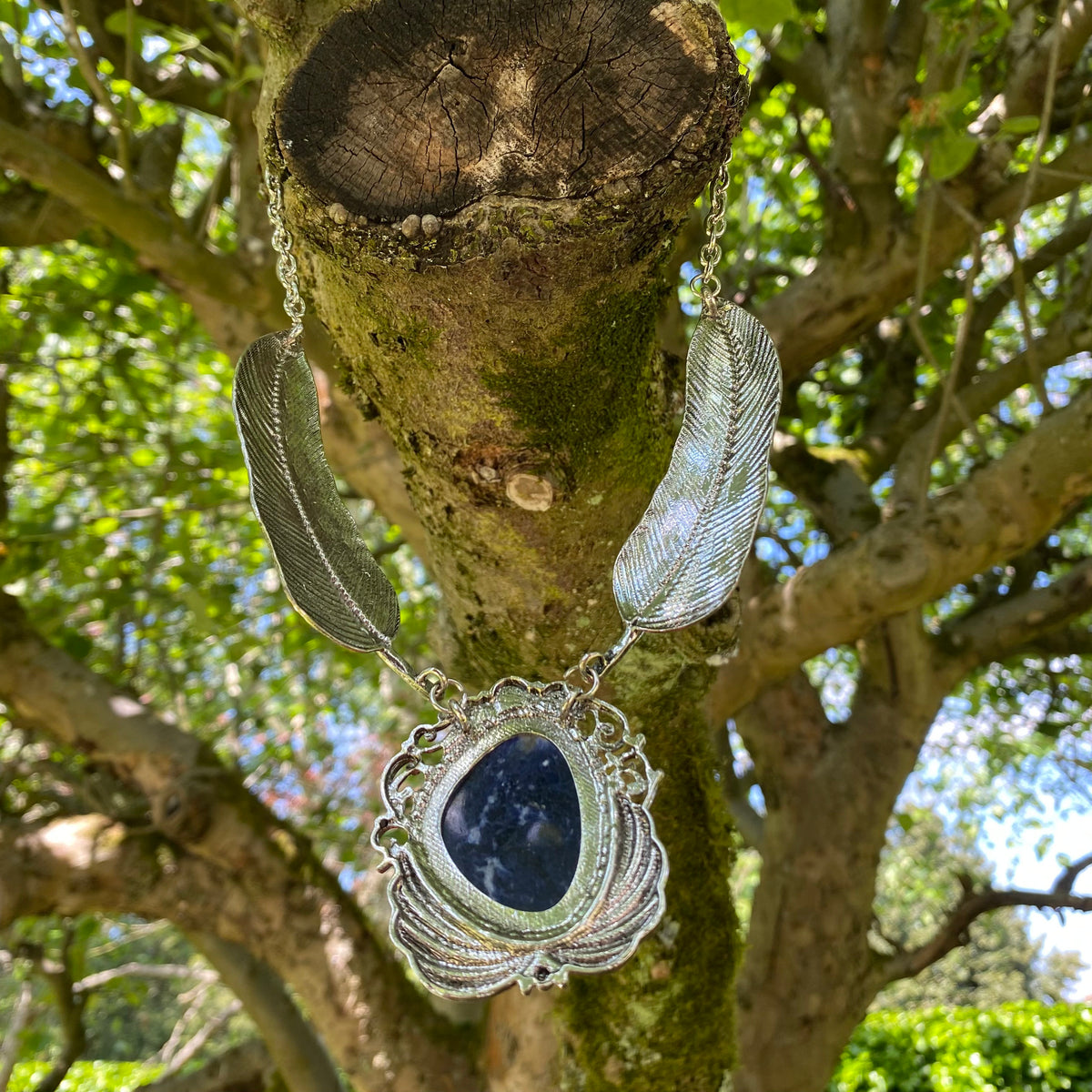 Silver feathered necklace with lapis lazuli in tree setting, medieval LARP style.