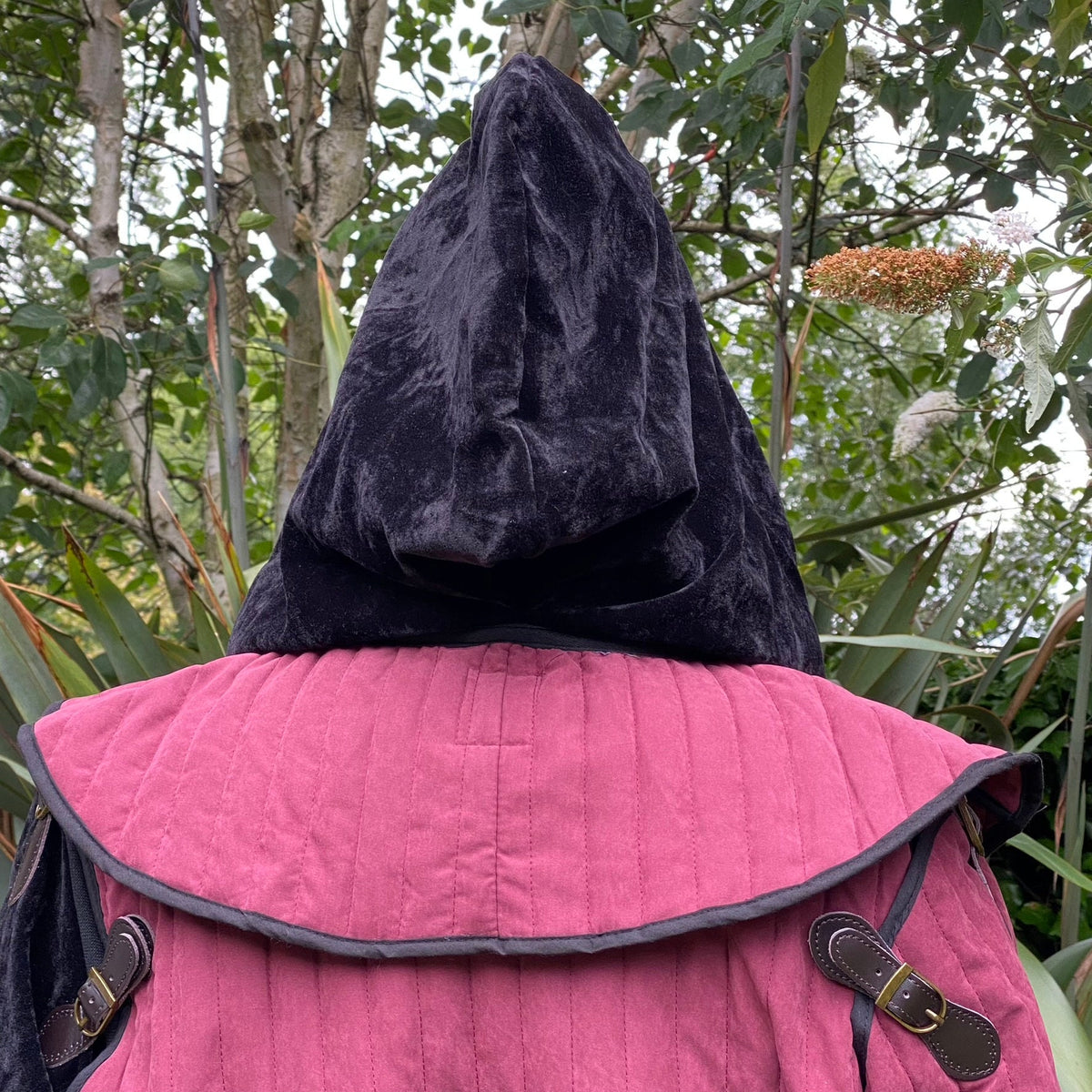 Back view of black velvet snood hood with red gambeson for LARP.