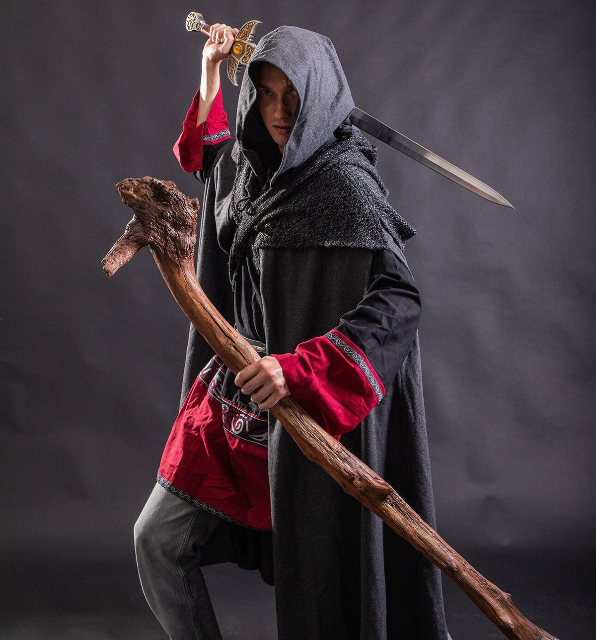 Model wearing grey hooded LARP cloak with sword and staff, medieval fantasy cosplay costume for.